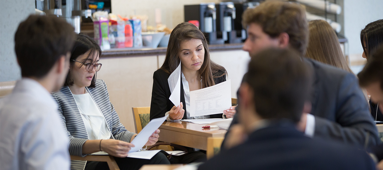 Group of students looking through handouts and talking