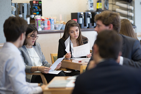 Group of students looking through handouts and talking